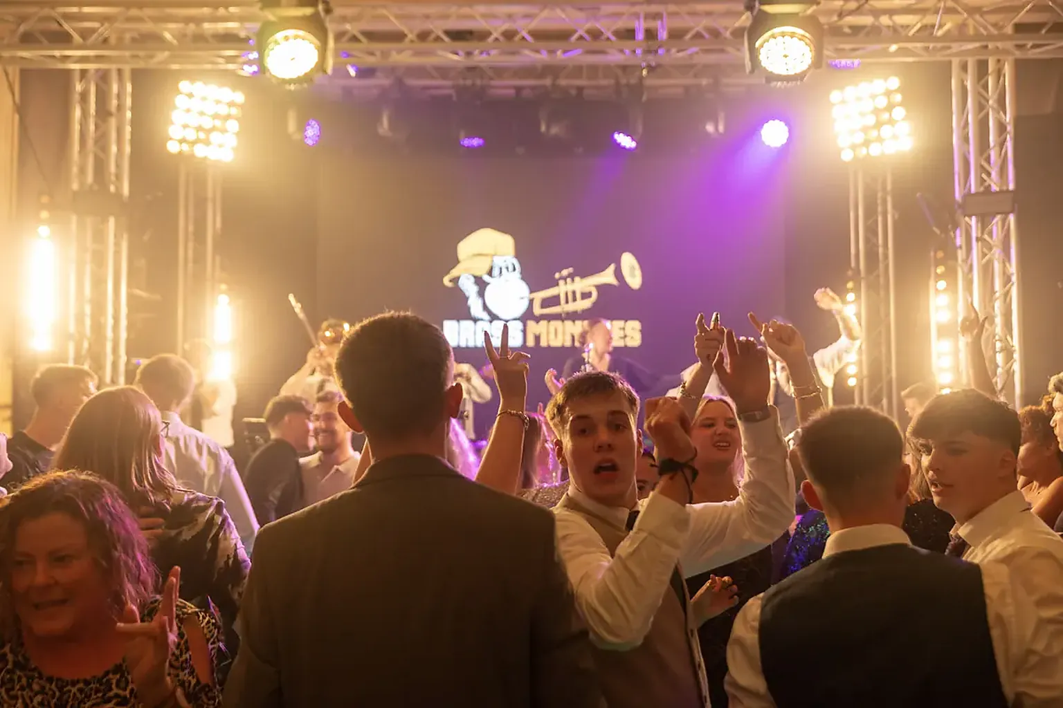 A packed dancefloor at a company party with Brass Monkees playing