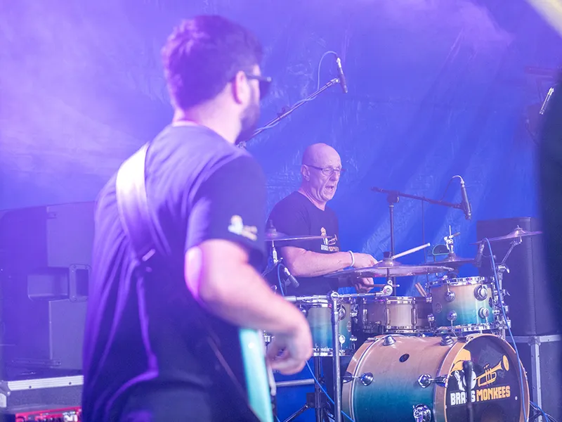 Brass Monkees drummer and guitarist playing live on a festival stage