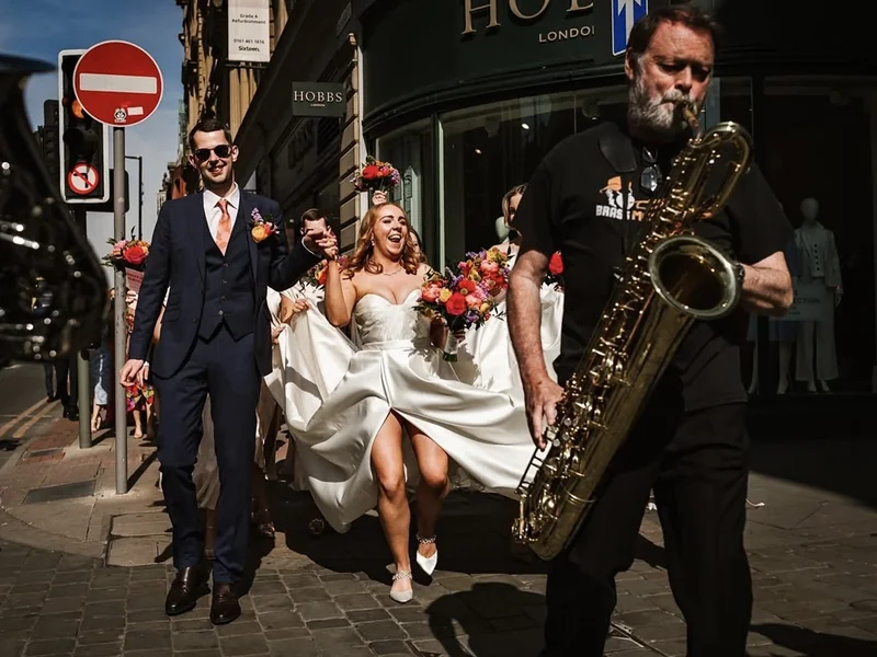 Roaming brass band leading a bride and groom at their Manchester wedding