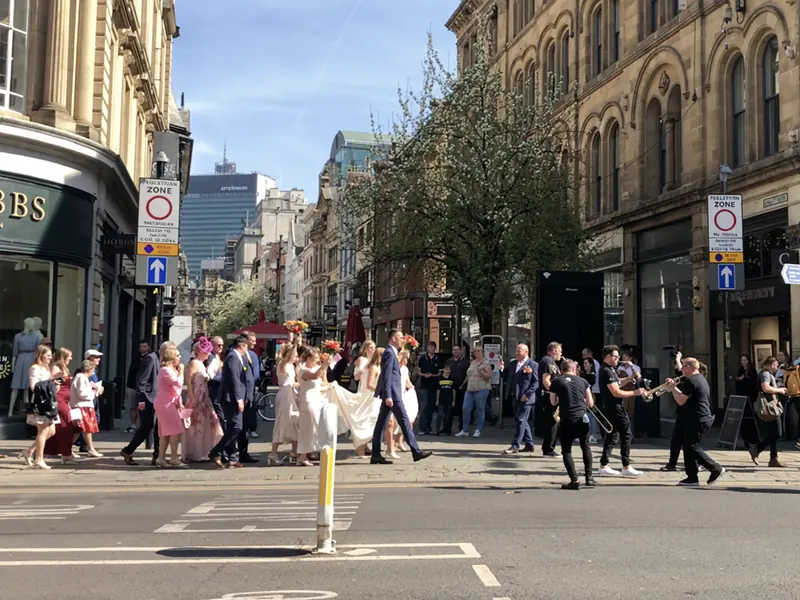 Roaming brass band leading a wedding procession through the city streets